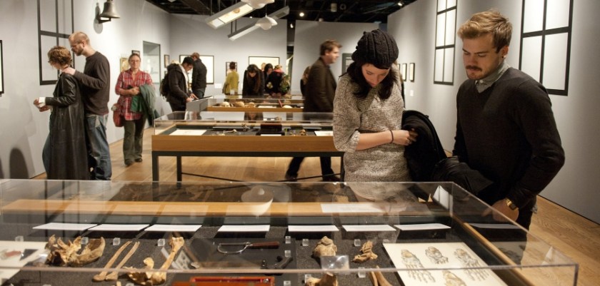 Crowds look at display cases in an exhibition